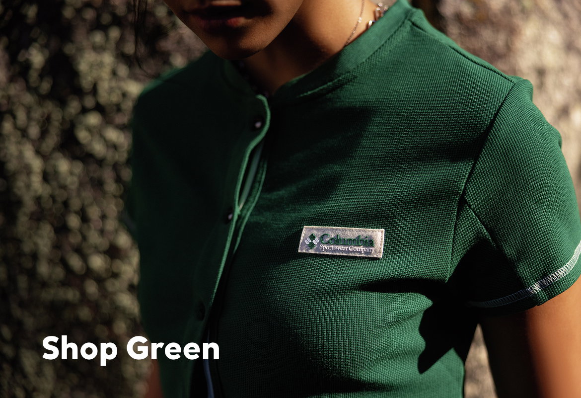 A woman wearing a green shortsleeved button up. 