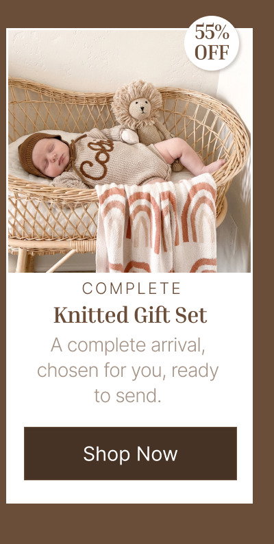 Flat lay of newborn items including personalized knit products, plush toys, and soft neutral baby accessories.