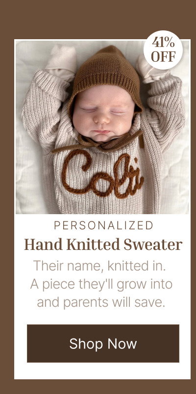Newborn baby wearing a brown personalized knit sweater while resting on a cream blanket with a small discount badge.