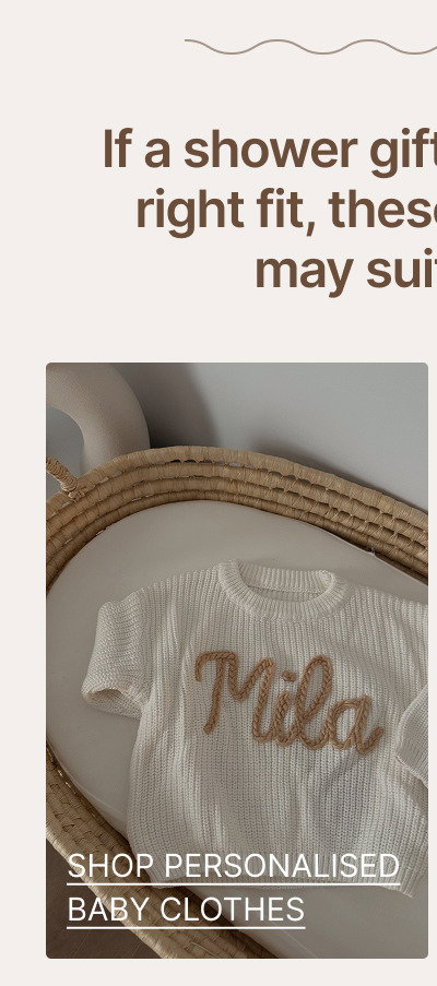Personalized baby clothes folded inside a woven basket with soft beige nursery fabrics surrounding the products.