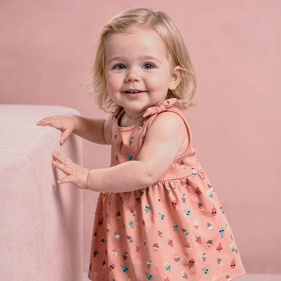 Mädchen trägt Kleid aus Baumwolle.