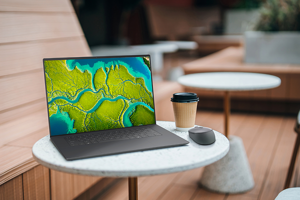 A Dell laptop computer and wireless mouse on an outdoor cafe table.