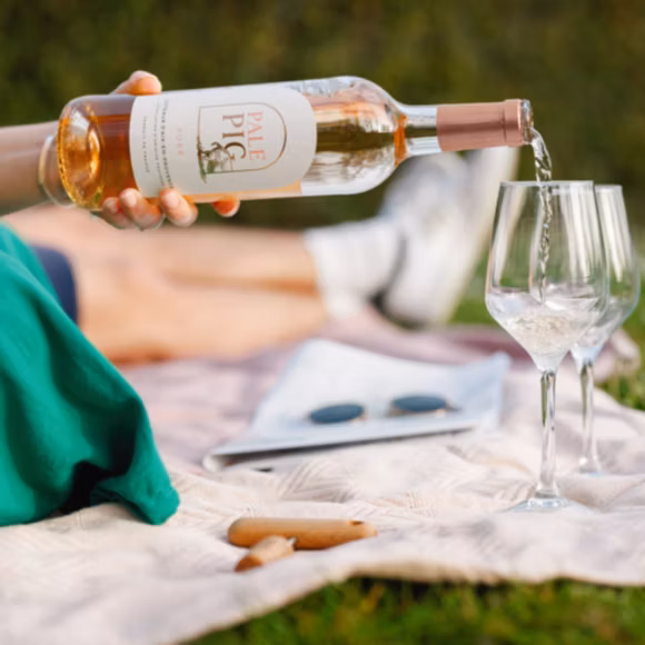 Someone pouring a glass of Pale Pig rosé from The Wine Flyer, linking to BA High Life site.