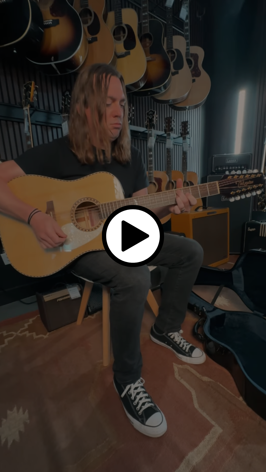 Man playing Takamine 12-string sitting next to TKL case