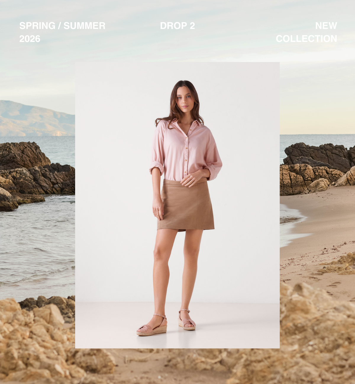 Woman wearing blush pink espadrille sandals styled with a soft pink shirt and beige skirt against a Mediterranean coastal backdrop.