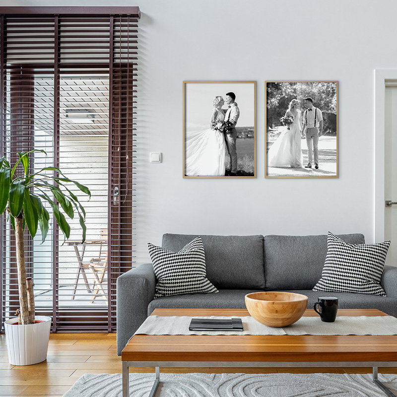 Contemporary lounge with grey sofa, wooden coffee table, and black-and-white wall prints.