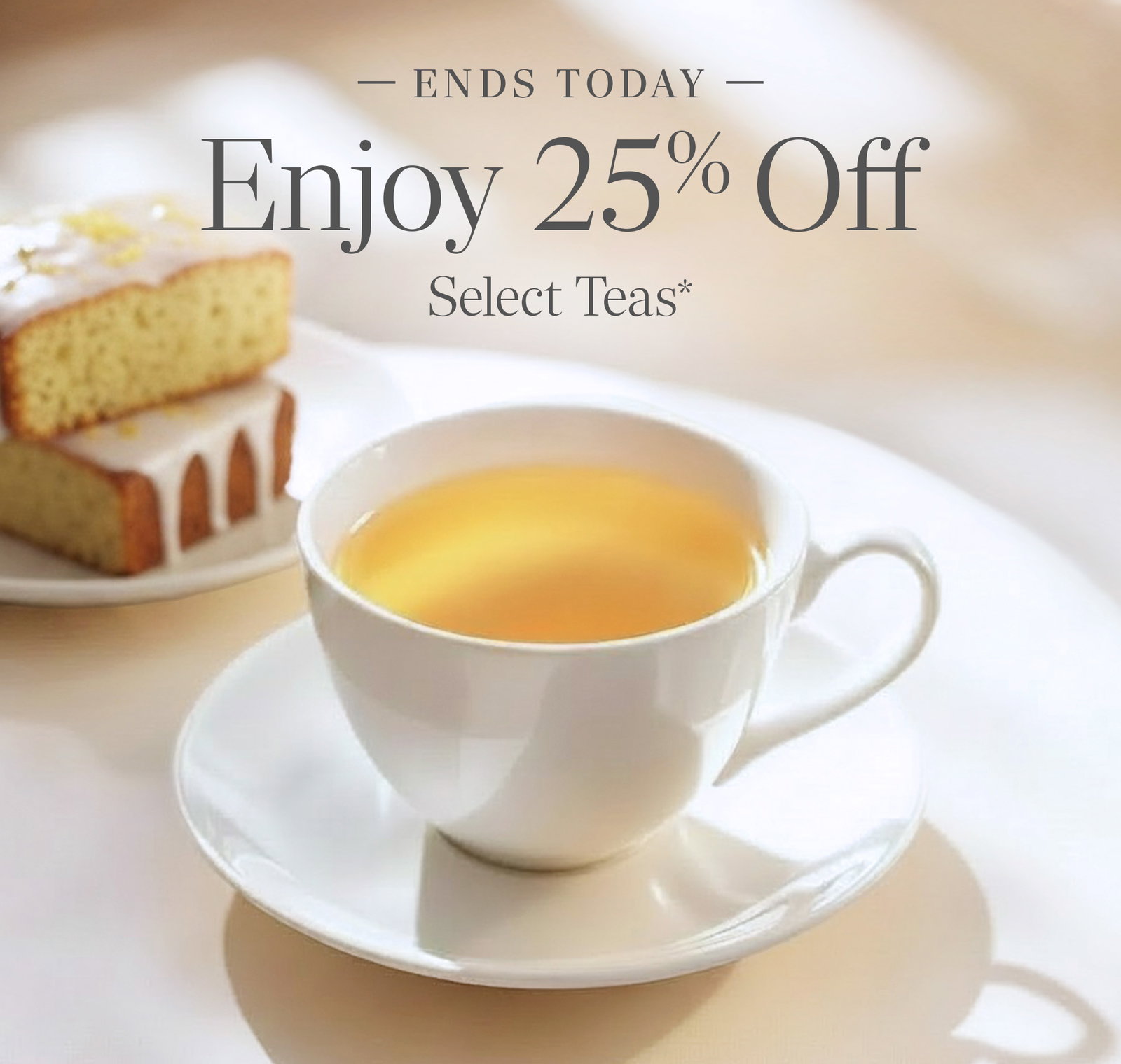 cup of First Flush Darjeeling in a teacup with two pieces of lemon teacake next to teacup in the background