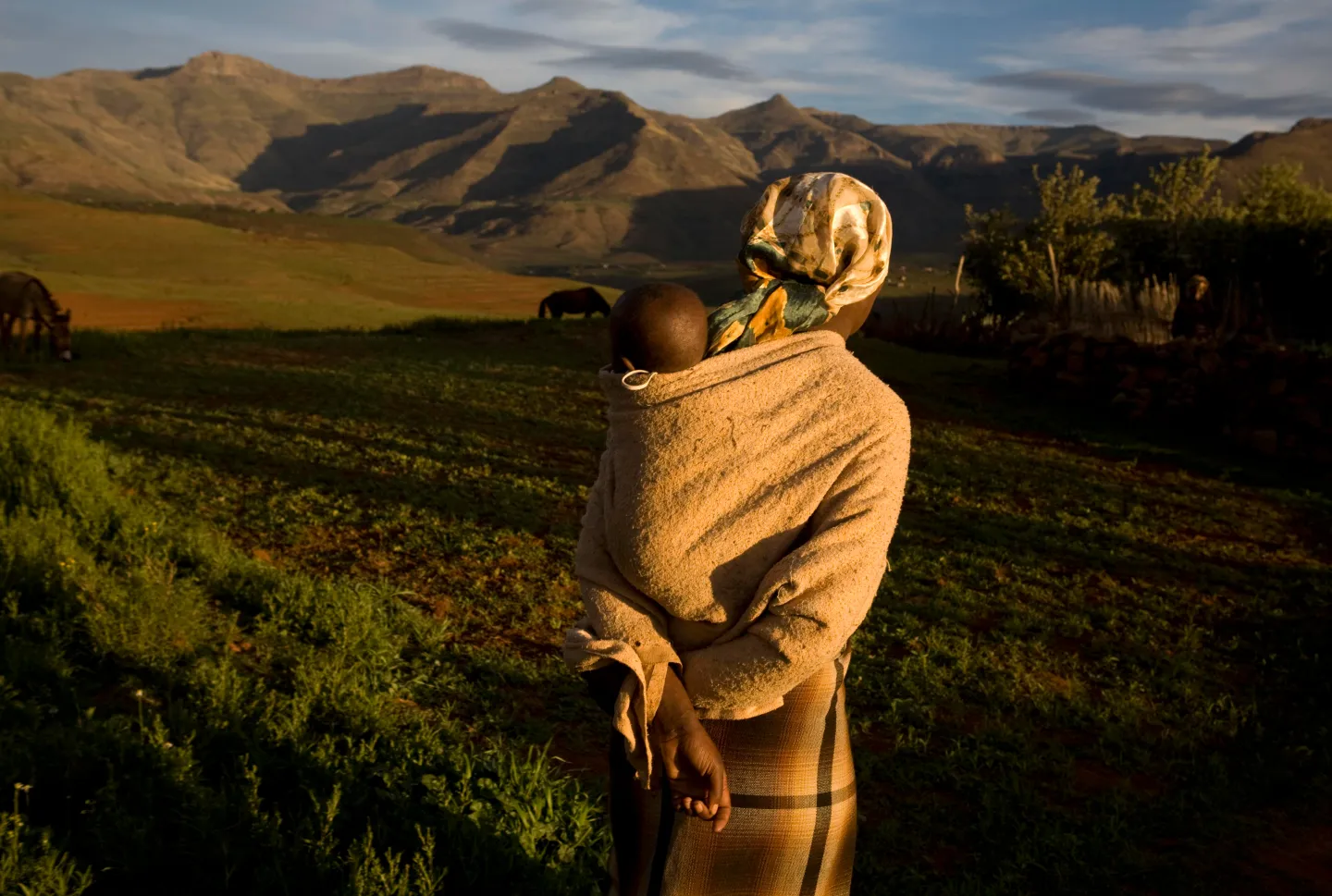 A photo of a person carrying a baby | Gideon Mendel/Getty Images