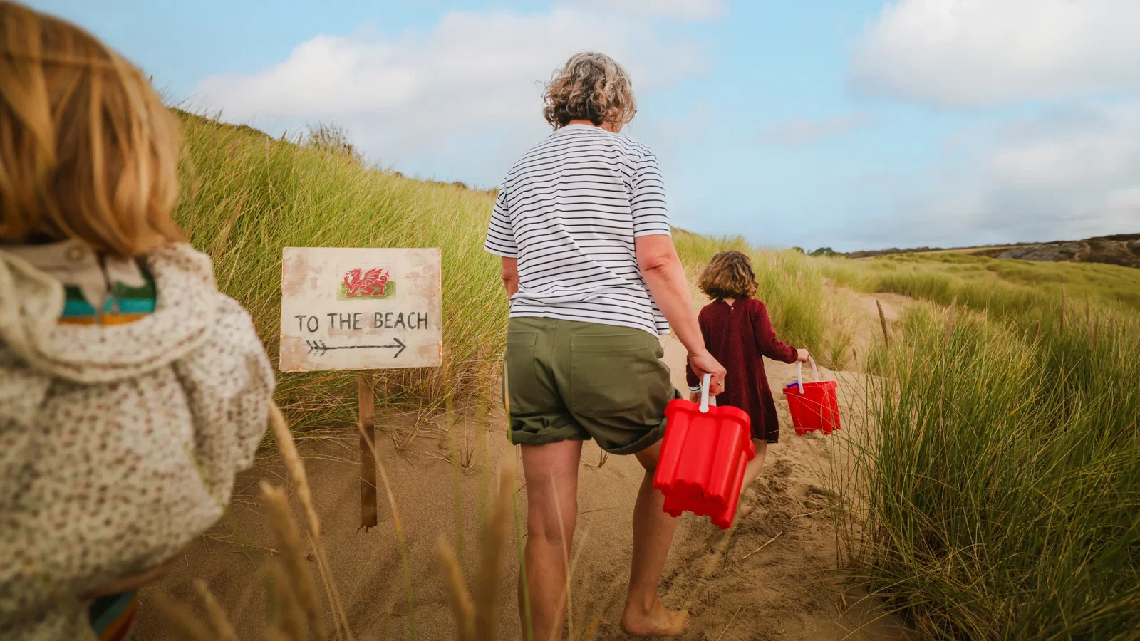 Family taking buckets and spades to the beach