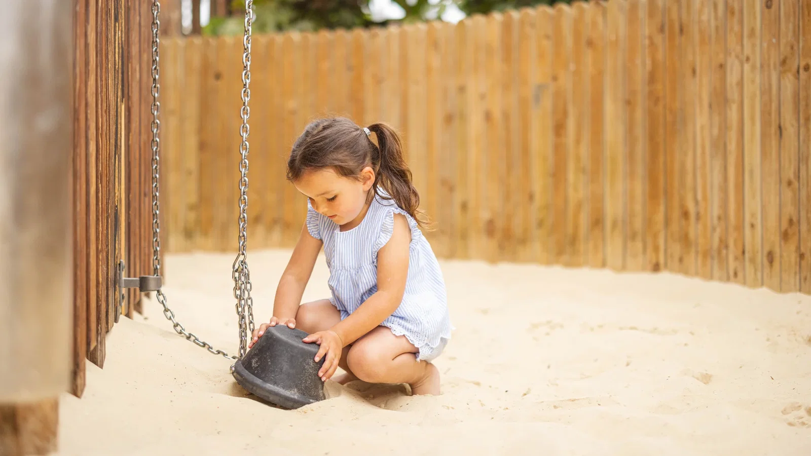 Child playing in the sand in the serendome