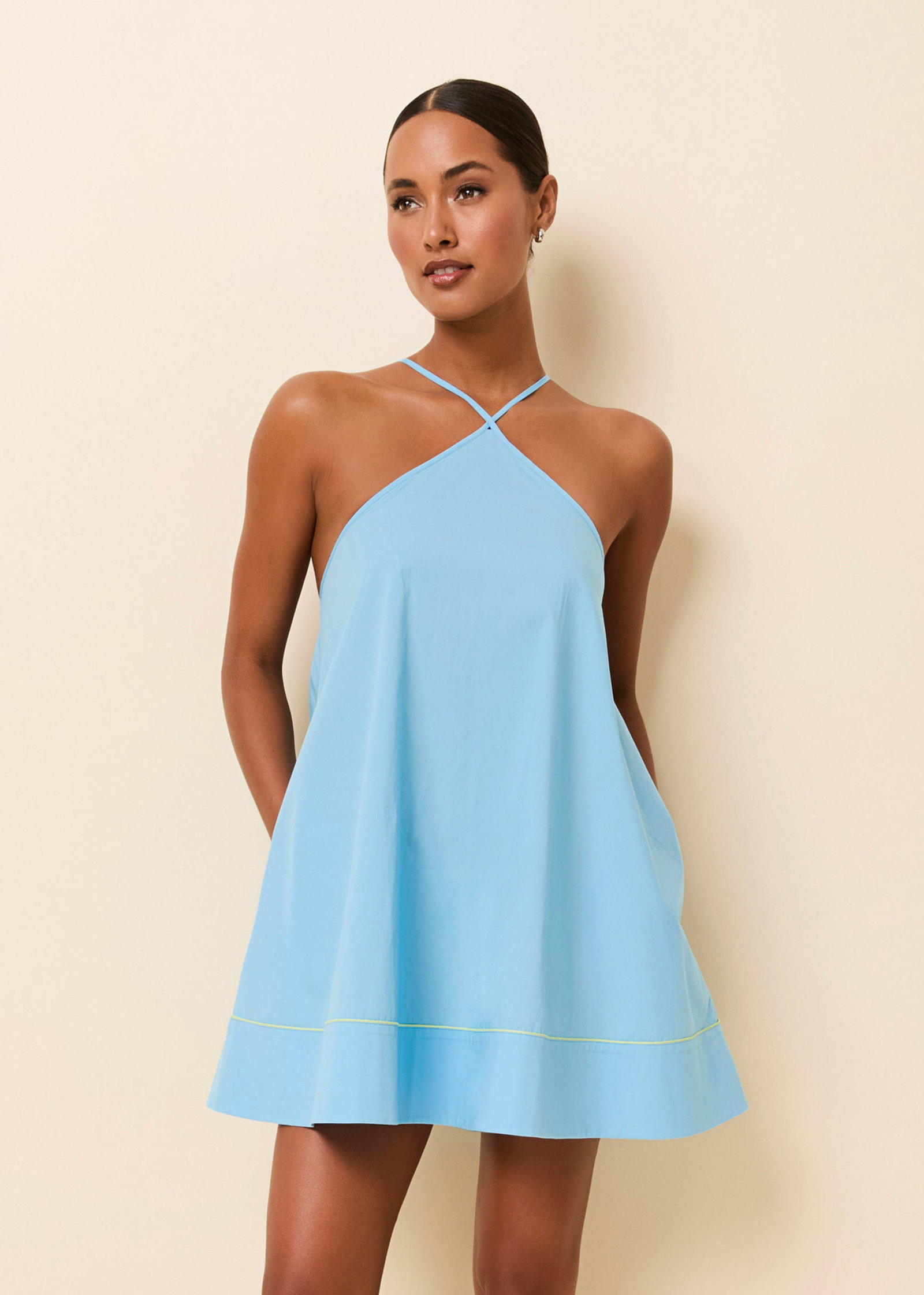 Woman in blue mini dress on beige background