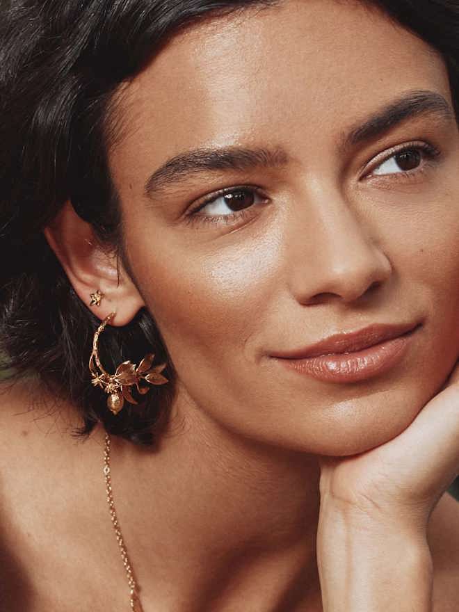A model wearing large gold Lemon Branch hoops from Alex Monroe