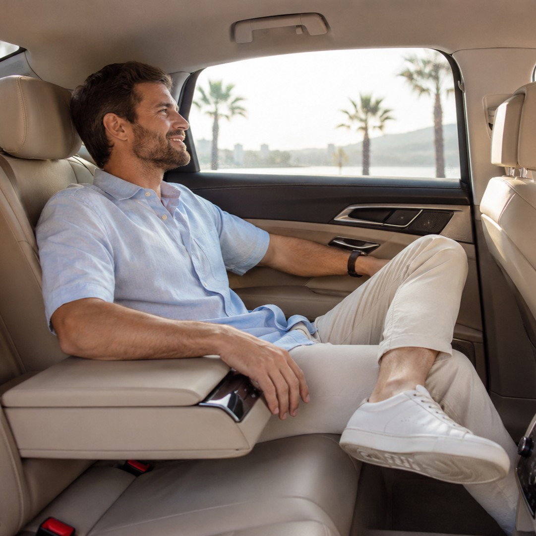 Passenger in a spacious airport transfer on a sunny day.