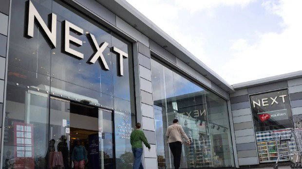 A Next store is seen with the logo looming large over passers-by as they walk outside the storefront on a cloudy day in Basildon.