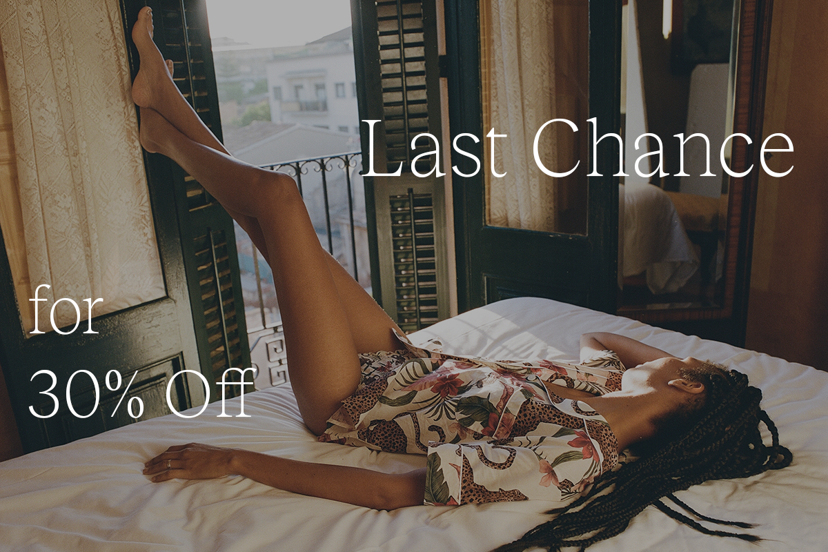 Model relaxing on a bed in printed Desmond & Dempsey sleepwear, with text reading “Last Chance for 30% off.”