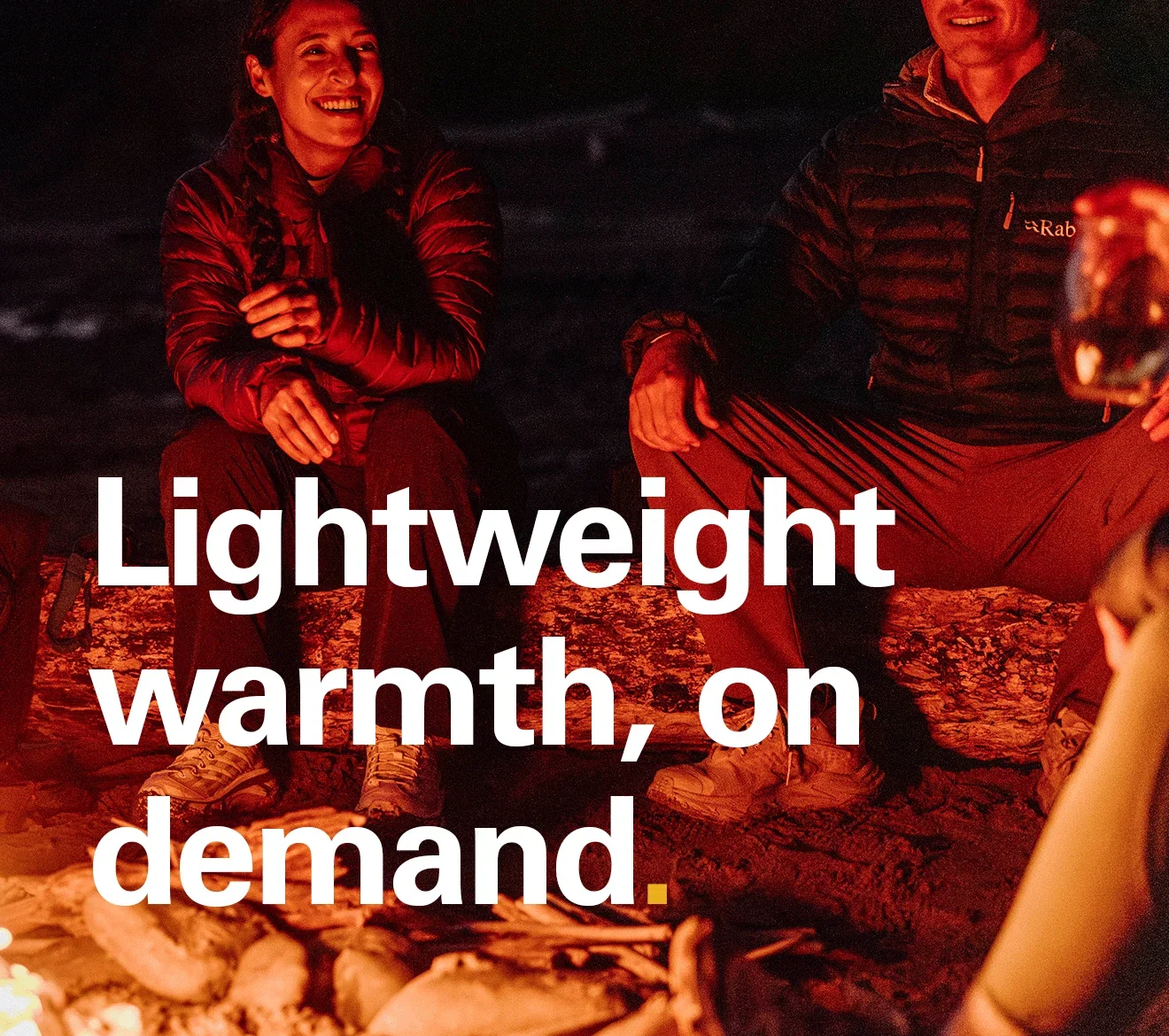 'Lightweight warmth, on demand.' text on the image of a group of people around a camp fire in the evening, all wearing Rab insulated jackets.