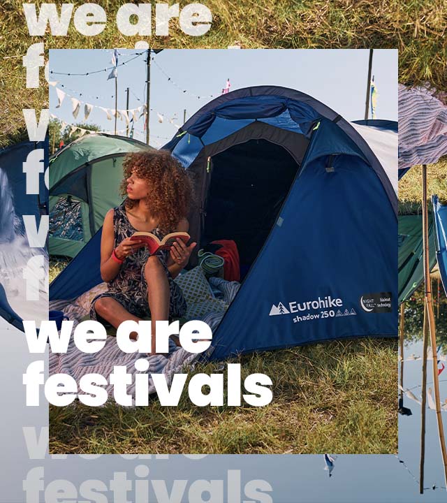 Woman sitting inside a blue tent at a festival 