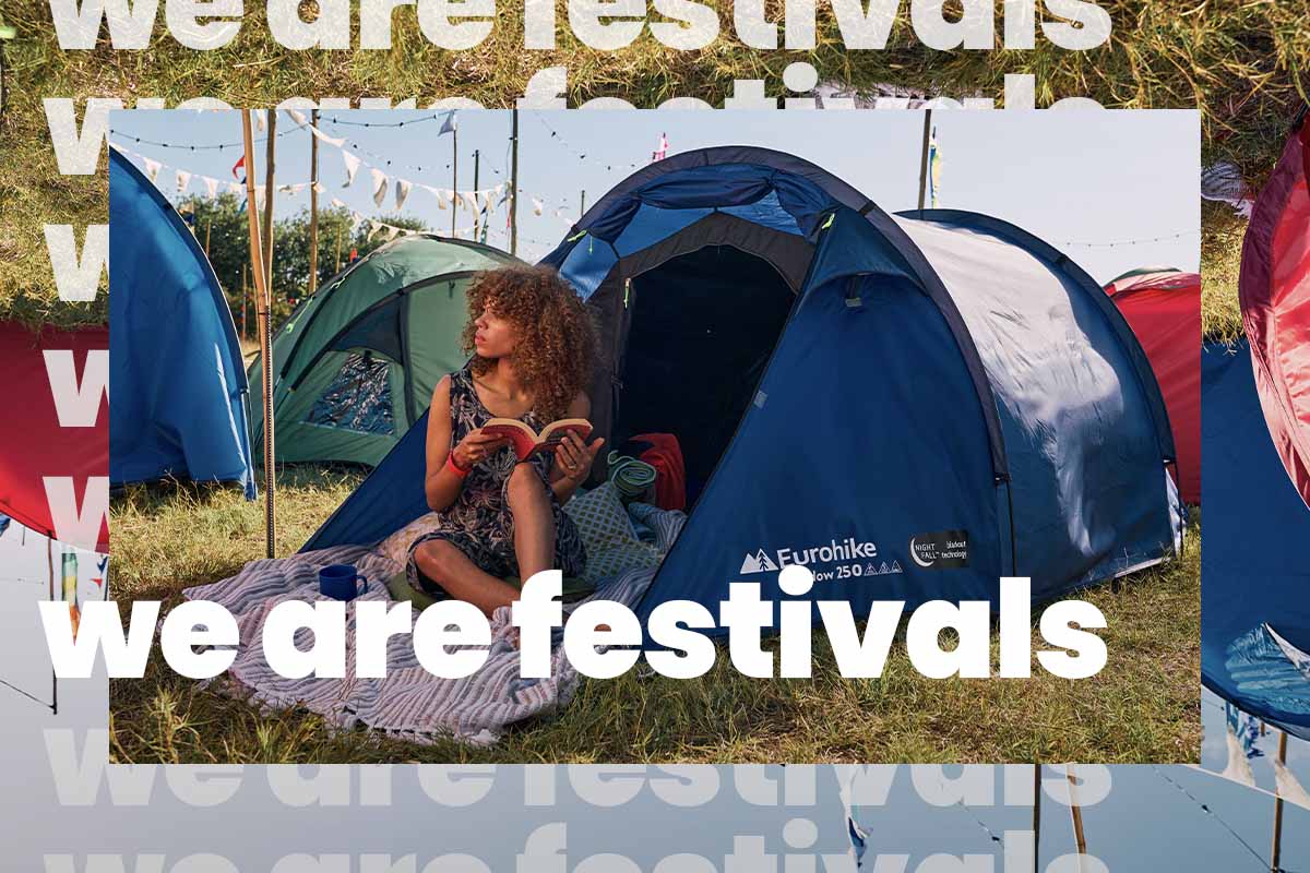 Woman sitting inside a blue tent at a festival 