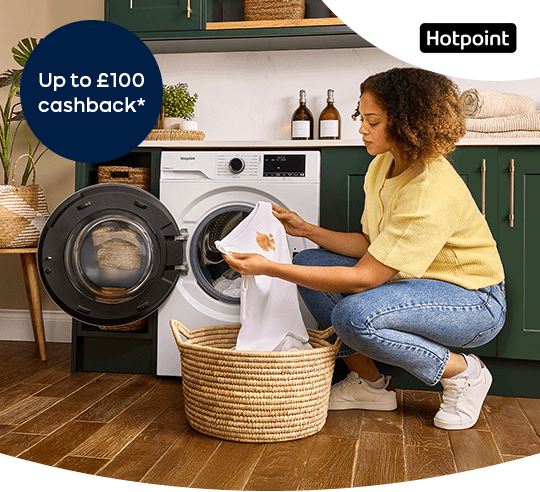 A woman taking laundry out of a washing machine.