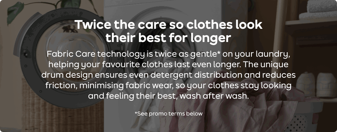 An open laundry appliance with clothes in a basket beside it.