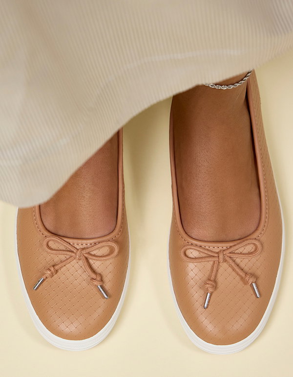 A close-up, top-down view of the Maisie Ballet Basketweave Emboss Leather flats in tan shown on foot paired with a beige knit maxi skirt.