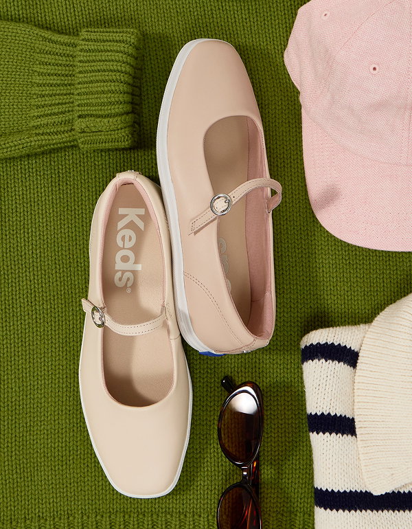 A top-down view of the Square Toe Mary Jane Leather in peony pink sitting artfully with a green knit sweater, sunglasses, and a pink baseball cap.