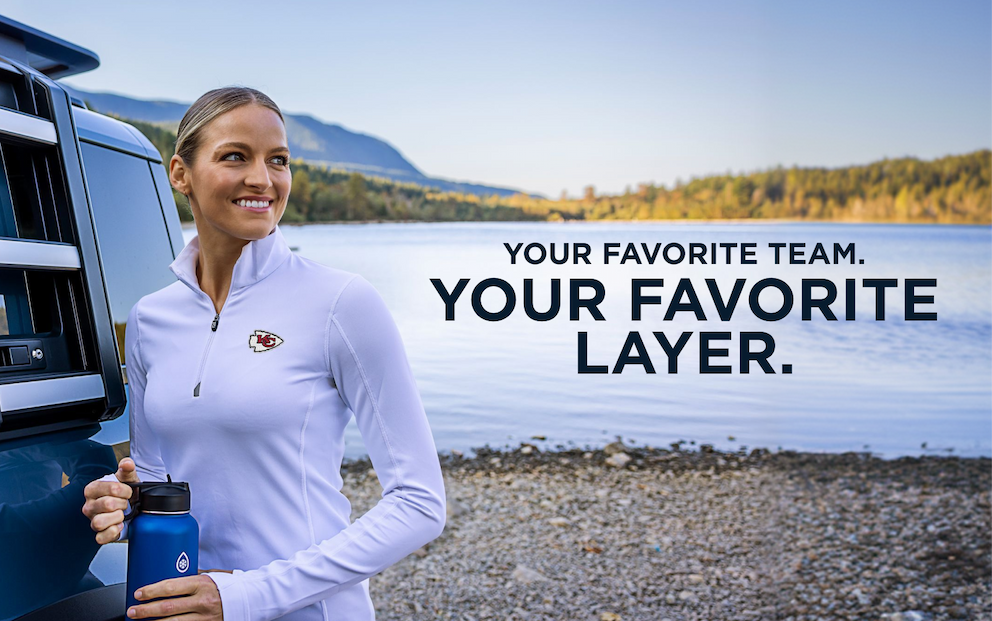 Woman wearing a white Traverse quarter zip and representing her favorite team