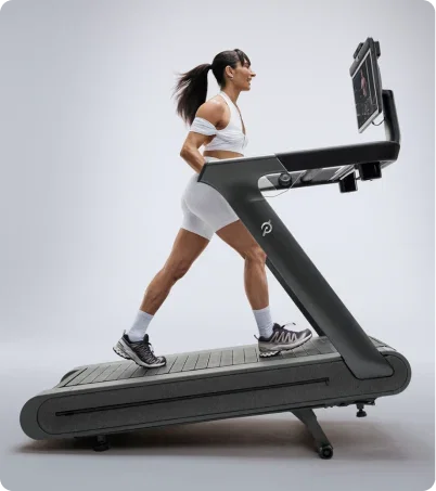 Woman wearing all white incline walking on the Peloton Tread Plus