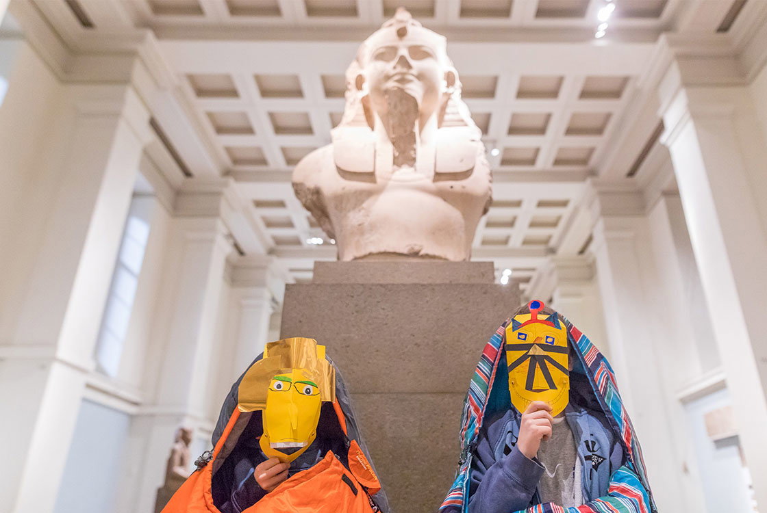 Two children in front of a statue of Ramessess II in the Egyptian gallery. 