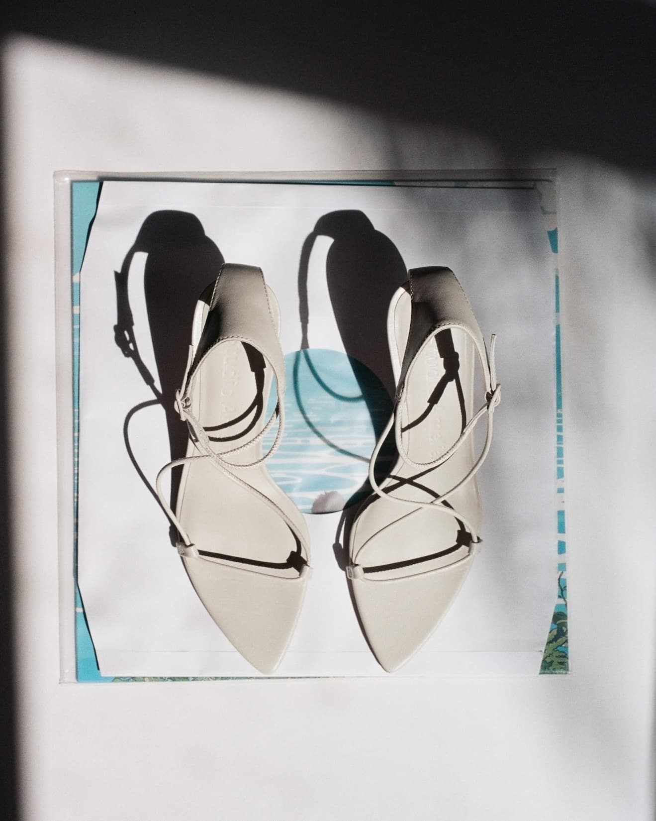A pair of white strappy high heel sandals