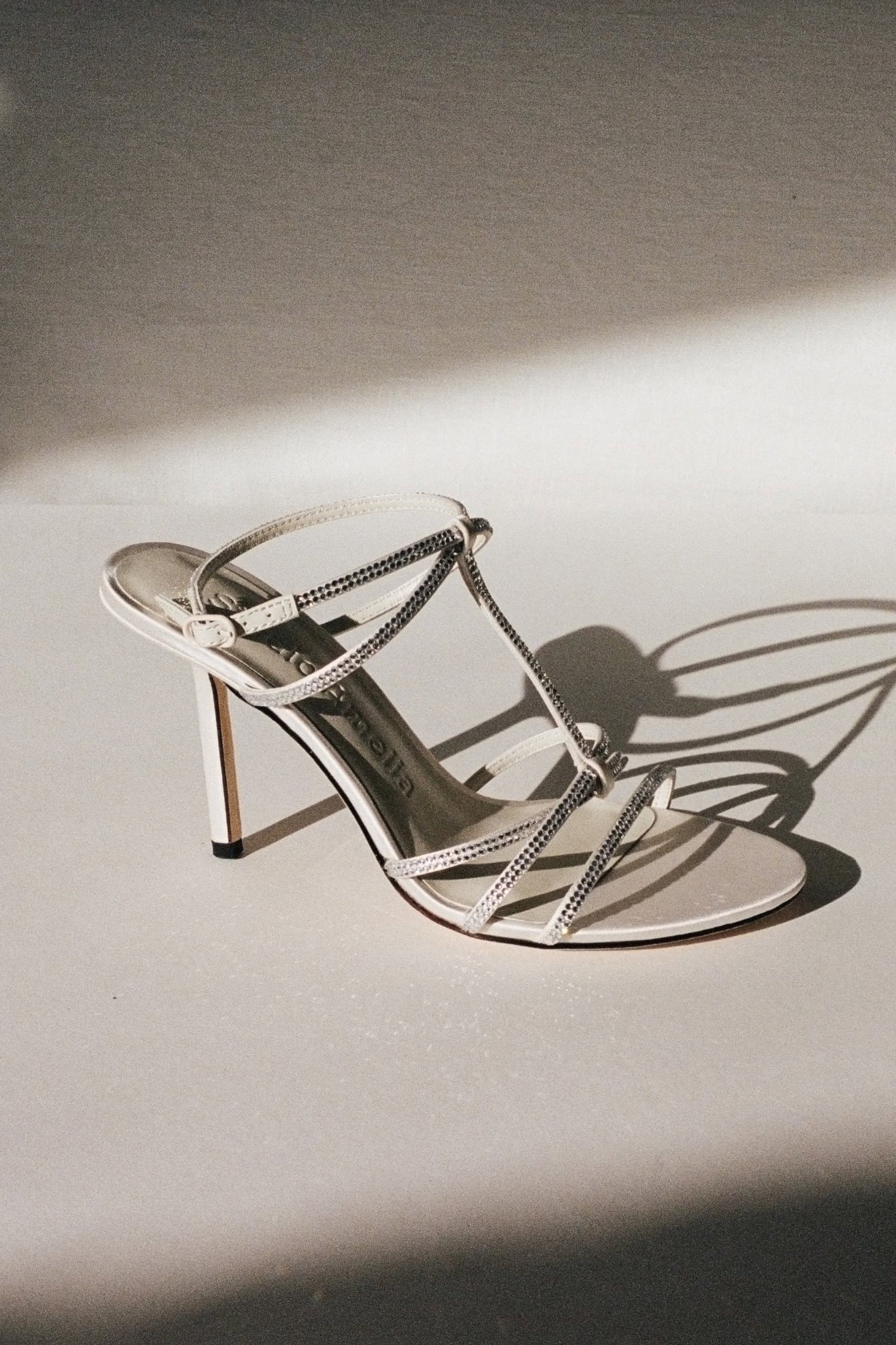 A white satin strappy sandal with diamante straps