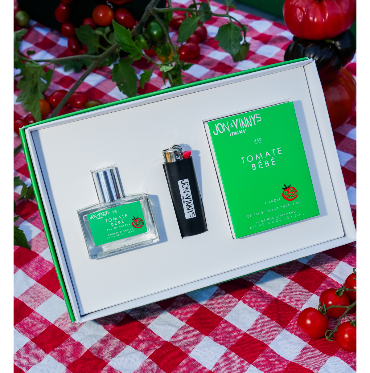 A Tomate Bébé fragrance bottle, branded lighter, and candle packaging in bright green collaboration branding.