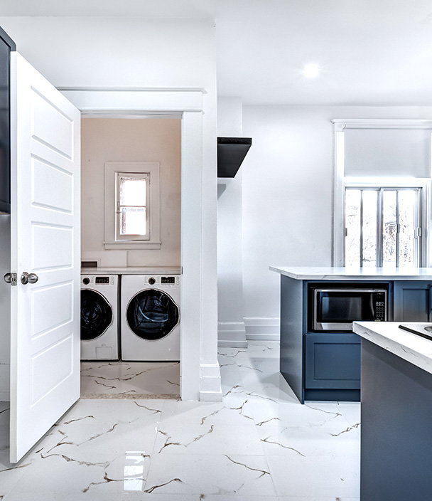 Modern home interior with a kitchen and a nearby laundry nook with a washer and dryer