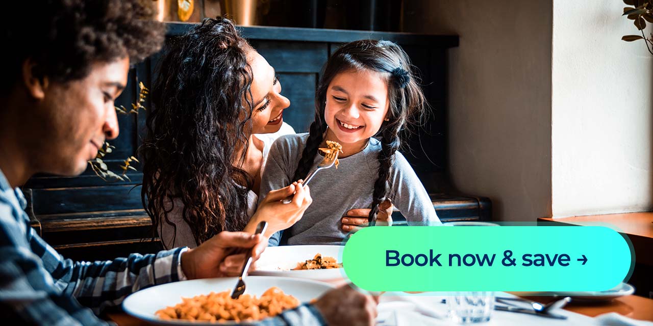 Smiling woman folds laundry beside a basket with a “Book now & save” button displayed.