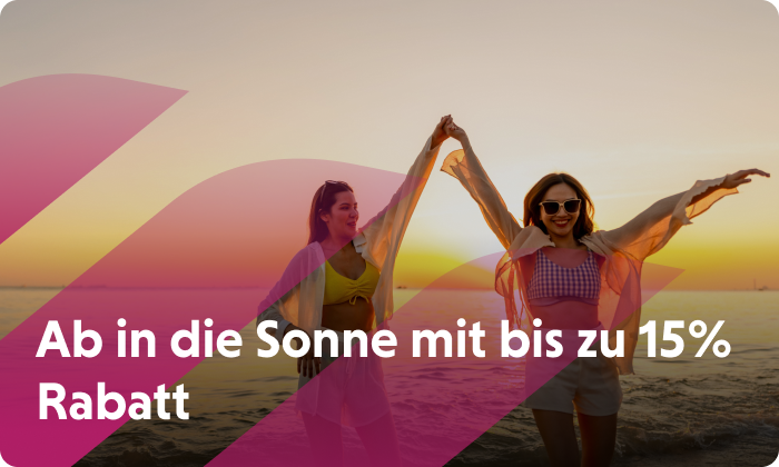 Zwei Frauen tanzen im Licht der untergehenden Sonne am Strand. Jetzt Flüge buchen und bis zu 10 % sparen.
