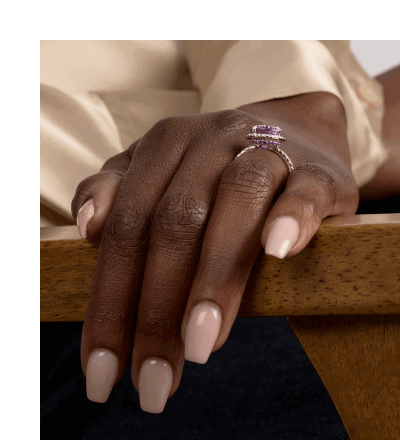 Close-up of female model wearing stacked purple amethyst and diamond pavé rings.