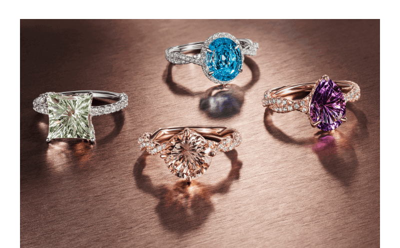 Colored gemstone rings featuring green quartz, blue topaz, morganite, and purple amethyst stones.