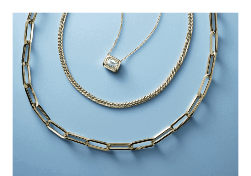 Stack of three gold necklaces.
