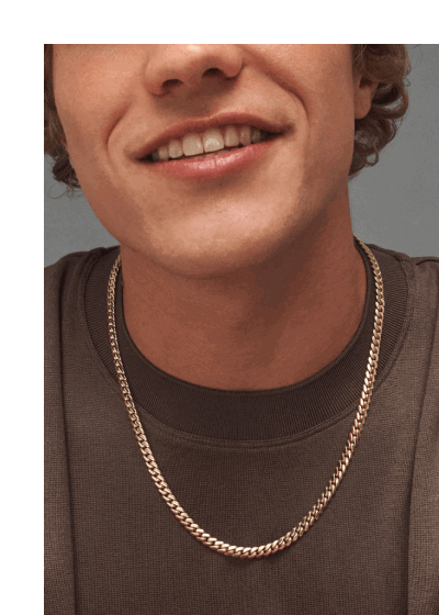Man wearing yellow gold chain necklace, yellow gold watch and yellow gold bracelet.
