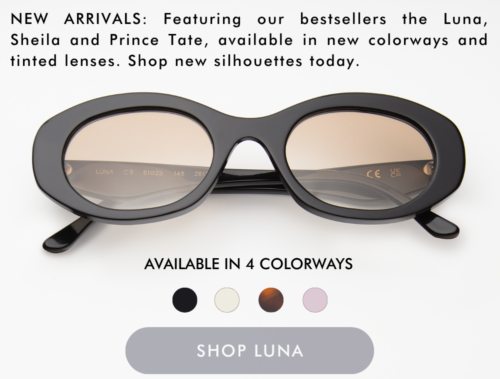 A studio product shot of the Luna sunglasses, featuring a thick, rounded oval black acetate frame with warm brown gradient lenses. Text above the glasses reads: 