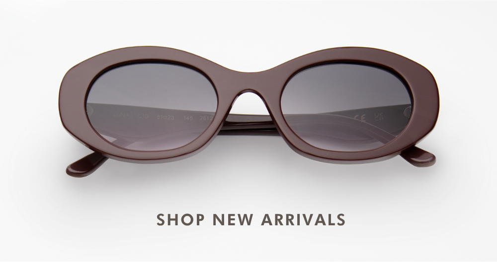 A studio product shot of the Luna sunglasses, featuring a thick, rounded oval acetate frame in a deep bordeaux colorway paired with dark grey lenses. Below the sunglasses, text reads 