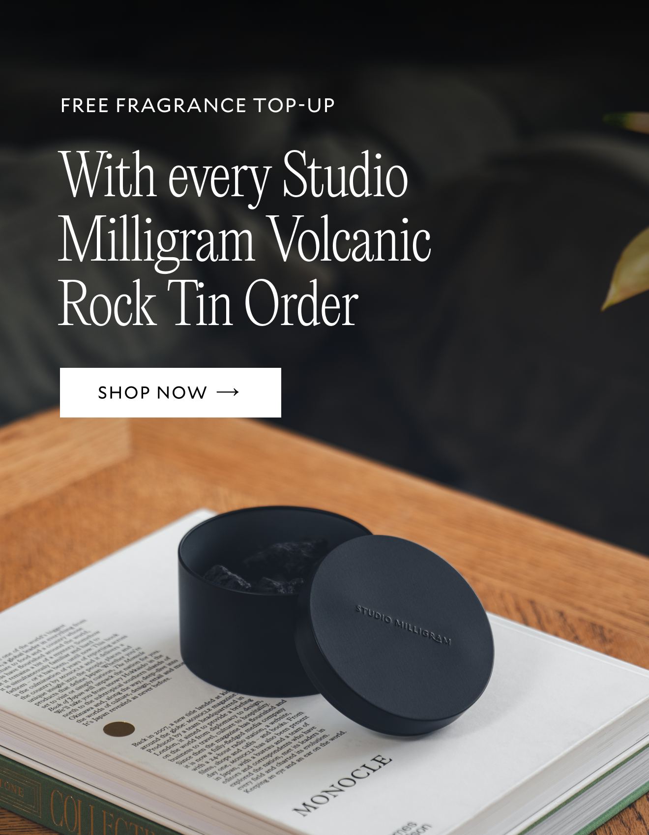 A Studio Milligram Volcanic Rocks Tin sits on a table atop a stack of books. Text reads Free fragrance top-ups with every Studio Milligram Volcanic Rocks tin order