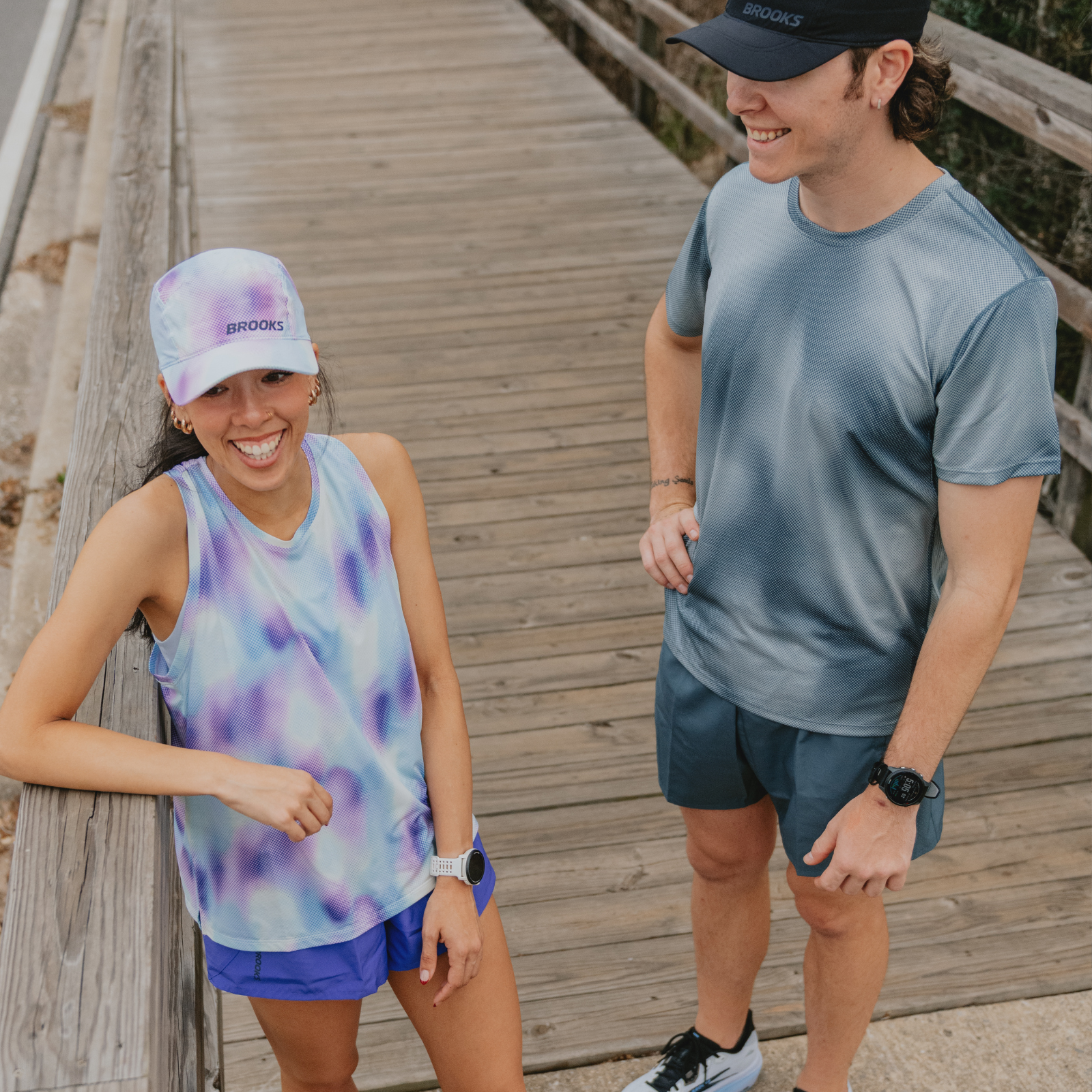 Two runners standing on a bridge