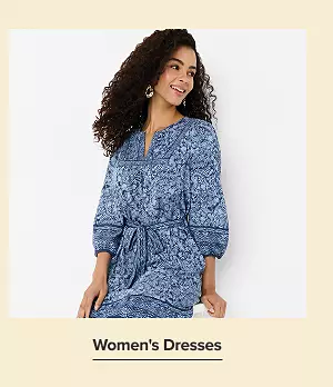 Shop womens dresses. A woman in a blue floral print dress.