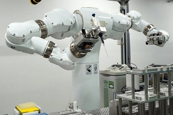 A two-armed Maholo LabDroid robot holding a pipette in one of its hands.