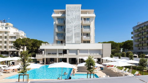 Hotel Außenansicht mit Pool und Liegen und Sonnenschirmen