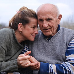 Woman holding senior father's hand