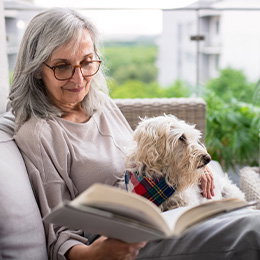 Senior woman reading with dog in her lap