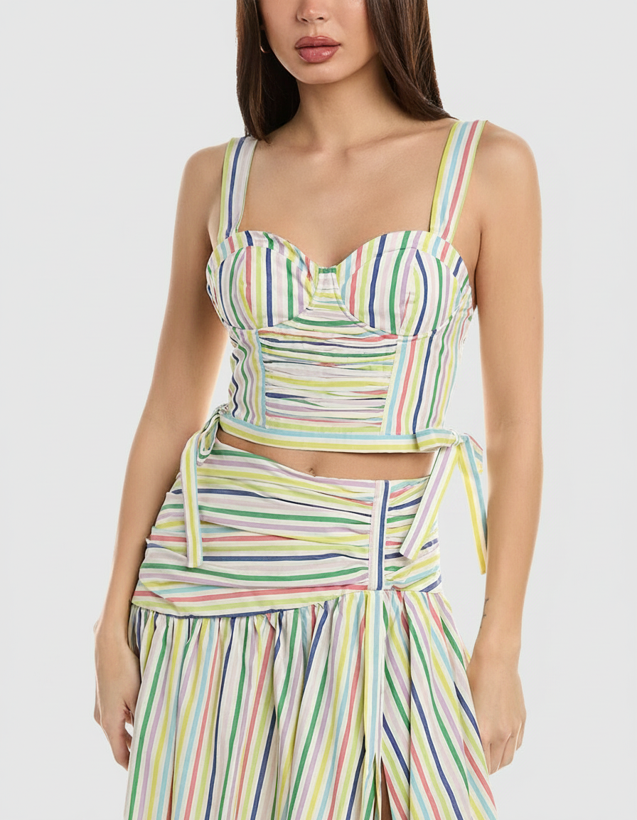 Woman in a colorful striped crop top and skirt set.