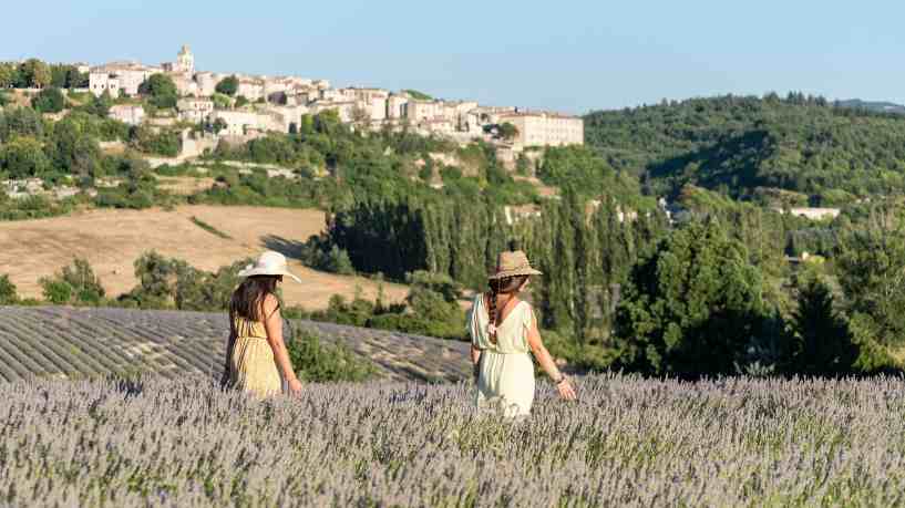 Two women walking in a lavender field